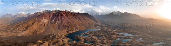 Atmospheric aerial view, high mountain landscape with glacier moraines and mountain lakes, behind