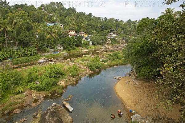 Indian people washing clothes in the Periyar River, Mundakayam, Kerala, India, Asia