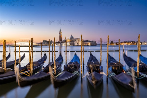 Venetian gondolas, boat dock at St Mark's Square, church of San Giorgio Maggiore in the background,
