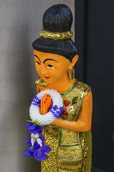 Figure with wreath of flowers at the entrance to the Thai massage parlour, Kaufbeuern, Allgaeu,