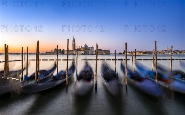 Venetian gondolas, boat dock at St Mark's Square, church of San Giorgio Maggiore in the background,