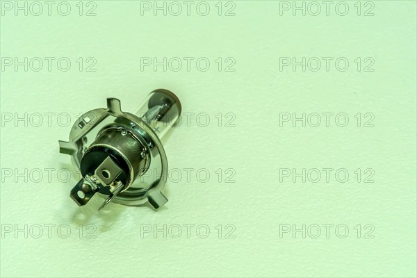 Automobile halogen headlamp bulb isolated on textured background