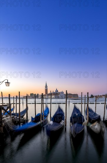 Venetian gondolas, boat dock at St Mark's Square, church of San Giorgio Maggiore in the background,