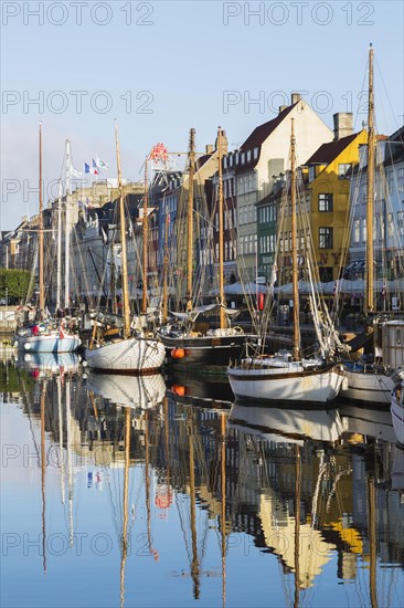 Moored sailboats and colourful 17th century apartment buildings and houses along the Nyhavn canal,