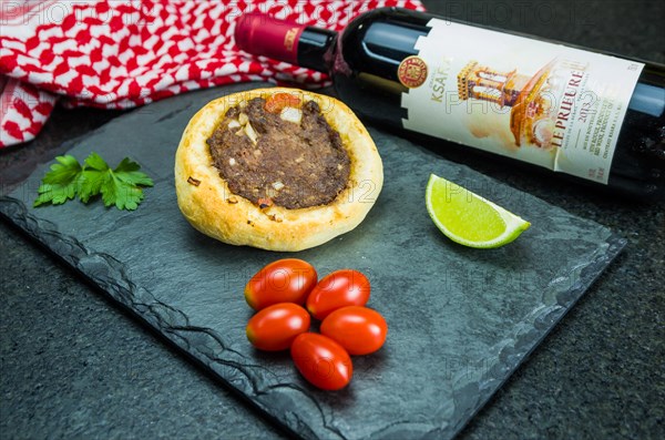 Delicious Lebanese (Arabic) food, legitimate sfihas on a black granite background with tomatoes,