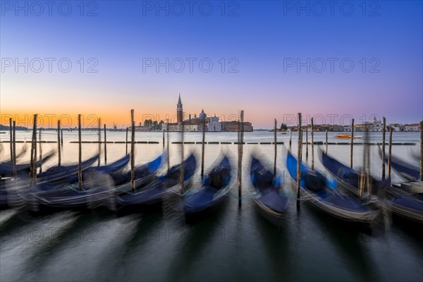 Venetian gondolas, boat dock at St Mark's Square, church of San Giorgio Maggiore in the background,