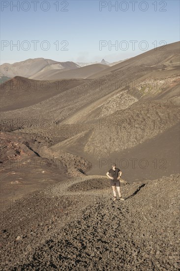 Young woman walking through lava fields, Crater Navidad, Lonquimay volcano, Malalcahuello National