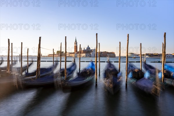 Venetian gondolas, boat dock at St Mark's Square, church of San Giorgio Maggiore in the background,