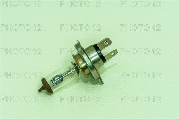 Automobile halogen headlamp bulb isolated on textured background
