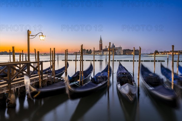 Venetian gondolas, boat dock at St Mark's Square, church of San Giorgio Maggiore in the background,