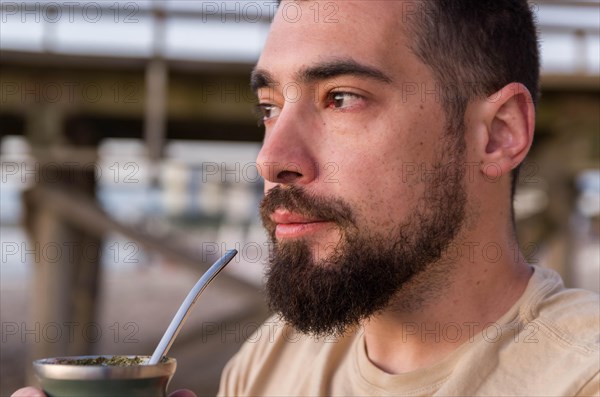 Man drinking chimarrao, mate tea tea (an infusion of yerba mate tea tea with hot water) at sunset