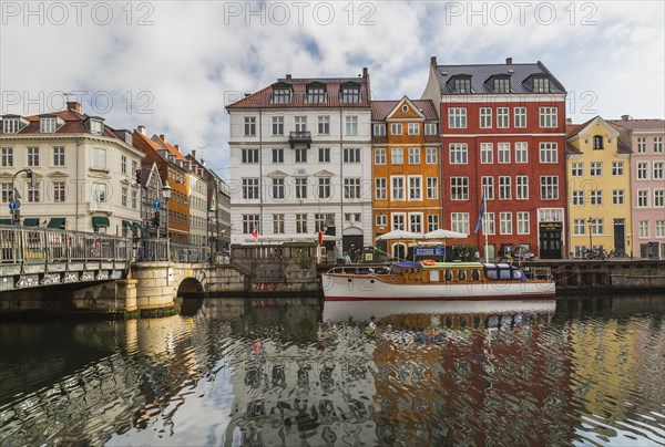 Canal bridge with moored boat and colourful 17th century apartment buildings and houses along the
