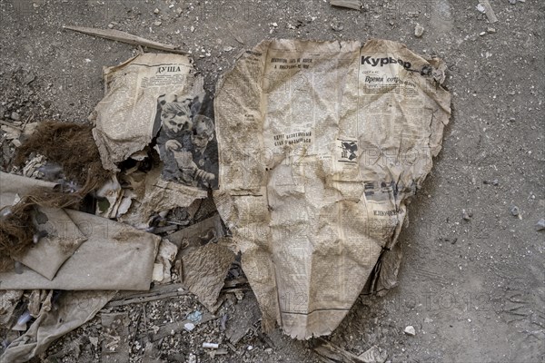 Remains of an old Kyrgyz newspaper from 1924 with Cyrillic writing in an abandoned building, ghost