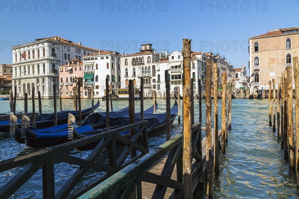Mooring poles and gondolas on Grand Canal with Renaissance architectural style residential palace