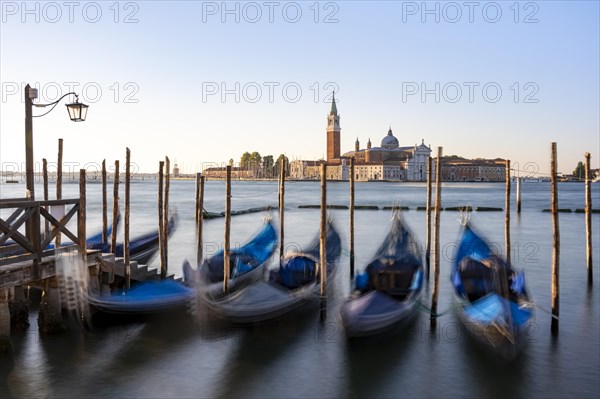 Venetian gondolas, boat dock at St Mark's Square, church of San Giorgio Maggiore in the background,