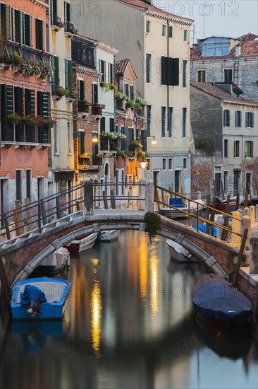 Moored boats and footbridge over Rio de la Toletta Canal with old architectural style residential