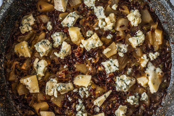 Closeup top view of frying pan with risotto with pear and blue cheese