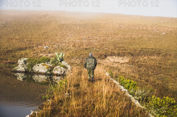 Sport fisherman fishing in lake on cloudy day, Cambara do sul, Rio Grande do sul, Brazil, South