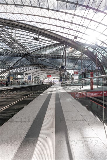 Spacious station concourse with glass roof and reflective surfaces, Berlin Central Station, Berlin,