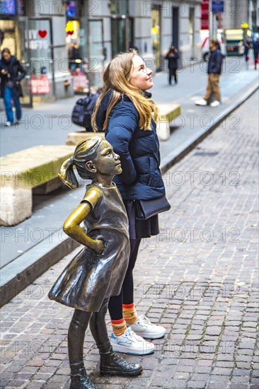 Bronze sculpture Fearless Girl by Kristen Visbal on Broad Street opposite the New York Stock
