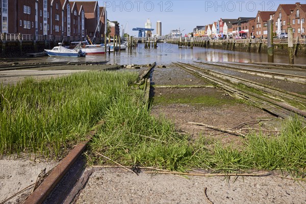 Old rusty rails with grass of the slipway of the old shipyard in the harbour of Husum, district of