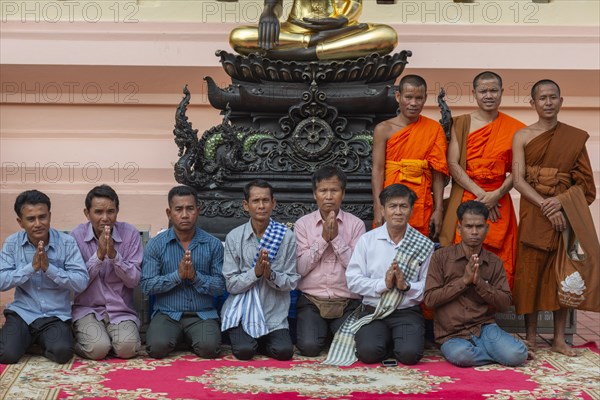 Monks and Laotians in front of a Buddha statue, Bhumispara-mudra, Buddha Gautama at the moment of