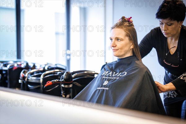 Valentyna Vysotska, hairdresser from Ukraine, bleaks her customer's hair, taken at the hairdressing