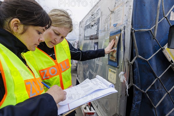 Customs officers check a load of an aircraft that has landed in the cargo area at the airport,