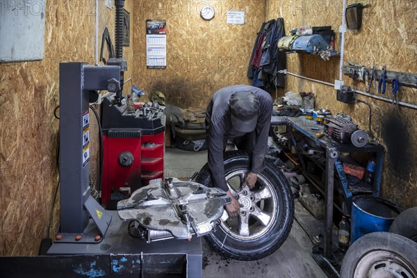Workshop, man repairing a hole in a car tyre, Kyrgyzstan, Asia
