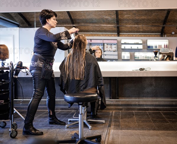 Valentyna Vysotska, hairdresser from Ukraine, combs her customer's hair, taken at the hairdressing