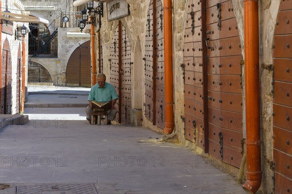 Man reading the Coran, Mardin bazaar, Turkey, Asia