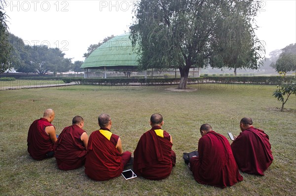 Tibetan monks, reciting sacred texts, tablet, smartphone, buddhism, stupa, Vaishali, Bihar, India,