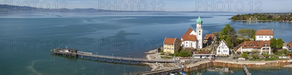 Moated castle peninsula with castle and parish church of St George on Lake Constance. Aerial photo,