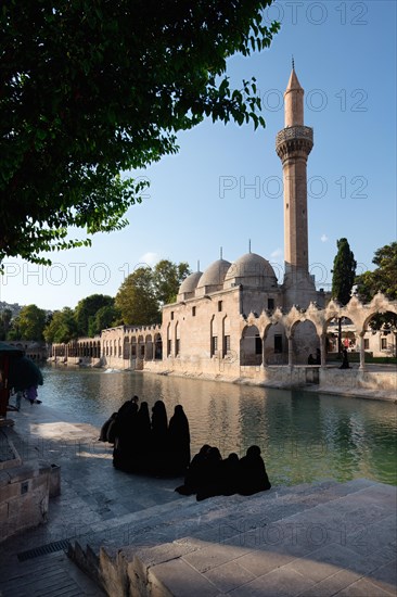 Muslim women wearing abaya in front of Abraham's Pool where the prophet was thrown into fire by