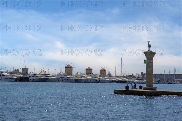 Deer Elafos, sculpture on a column, at the entrance to the harbour, in the background the three