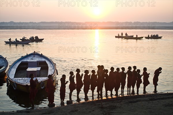 Schoolboys from a gurukul (hindu school), praying the rising sun, praying the hindu god Surya,