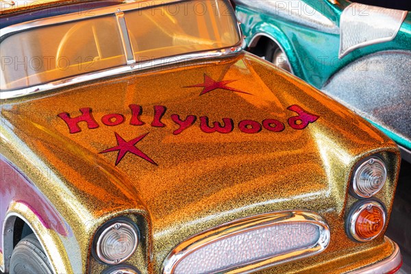 Car in a children's carousel with the inscription Hollywood, glitter and glamour, Spring Festival