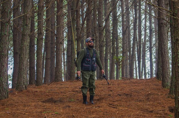 Fisherman walking in pine forest, Cambara do sul, Rio Grande do sul, Brazil, South America