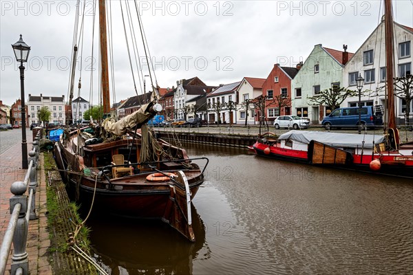 Old ships in the old harbour in the small town of Weener, at the back left historic Baerchen villa,