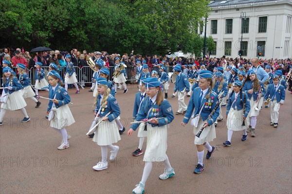A marching band with young people walks the streets to the castle, folklore, bank holidays 17 May,