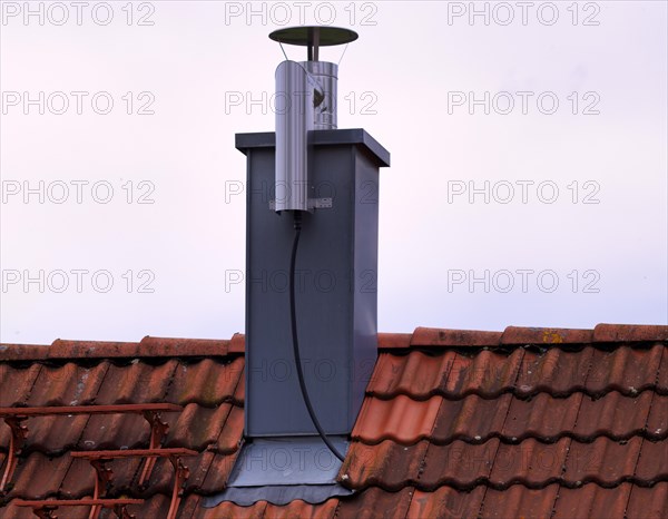 Retrofitted chimney on roof, with dust separator, electrostatic filtering of soot particles from