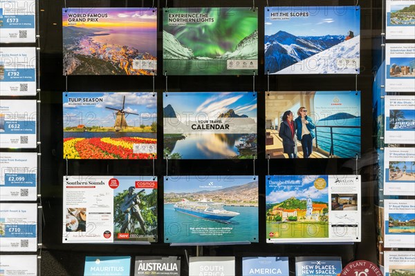 Colourful picture advertising holidays in shop window of travel agent, Woodbridge, Suffolk,