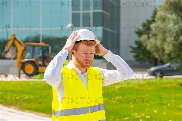 Architect wearing reflective waistcoat adjusting her safety hard hat in a construction site
