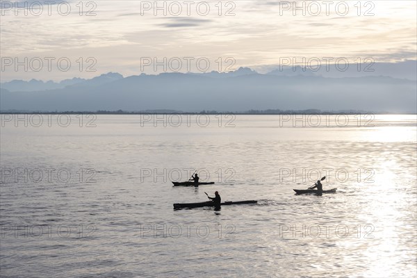 Kayakers paddling in Lake Constance in the evening light, snow-covered mountain peaks, Lindau