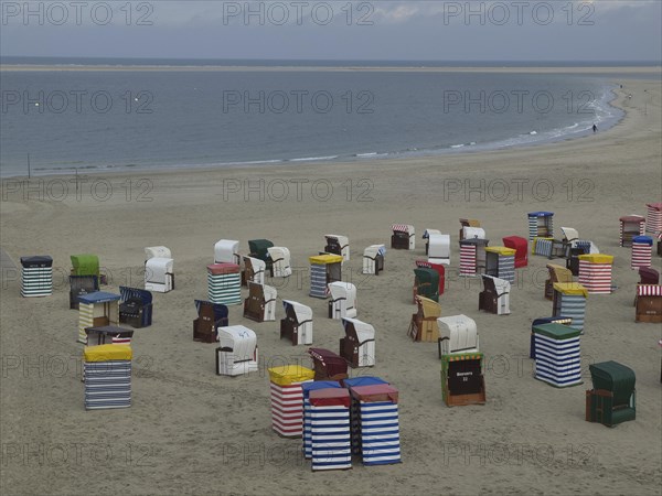 A multitude of colourful beach chairs on the extensive beach with the sea in the background, beach