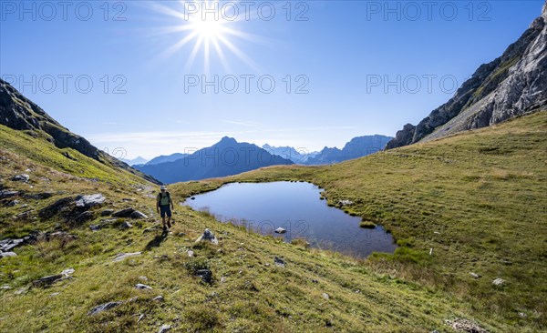Mountaineer at a mountain lake, Sonnenstern, Luggauer Toerl, Karnischer Hoehenweg, Karnischer