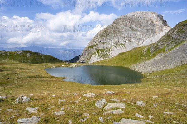 Mountain hut Obstanserseehuette at the mountain lake Obstansersee, behind rocky mountain peak