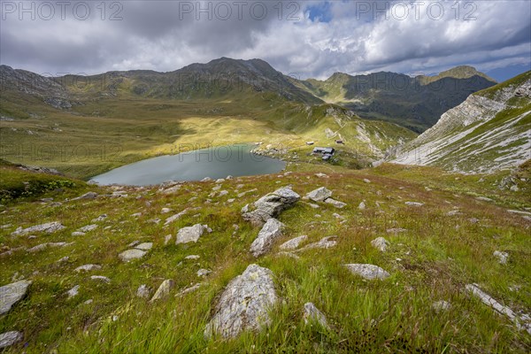 Obstanserseehuette mountain hut on the Obstansersee mountain lake between green mountain meadows,