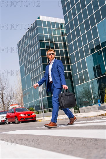 Vertical low angle view of a cool businessman crossing the street in the city