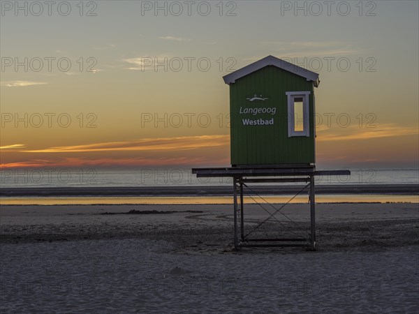 Langeoog Westbad rescue tower on the beach at sunset with a calm sea, beautiful sunset on the beach